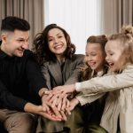A cheerful family of four bonding together indoors with smiles and joy.